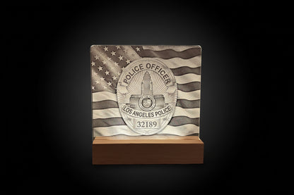 Decorative plaque with police officer badge and American flag design on a wooden block.